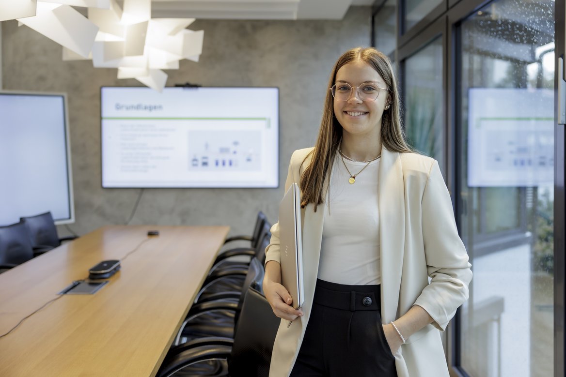 Auszubildende Auszubildende bei einer Besprechung im Besprechungsraum mit Bildschirm im Hintergrund